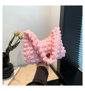 Détail de la texture froncée rose sur un sac à bandoulière au design plissé chic