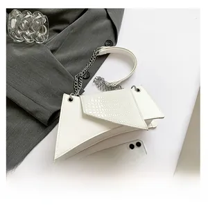 Detail of white geometric shoulder bag featuring crocodile pattern flap and silver chain