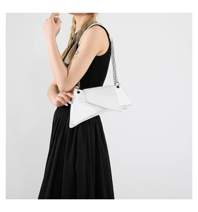 Detail view of white geometric shoulder bag with crocodile pattern and silver chain strap