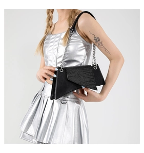 Detail of black geometric crossbody bag with asymmetrical cut and silver chain strap