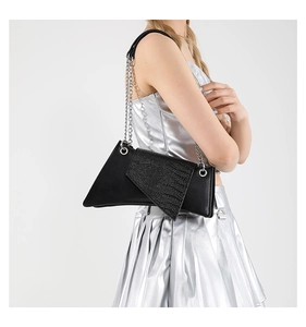 Detail of black geometric crossbody bag featuring embossed texture and silver chain strap