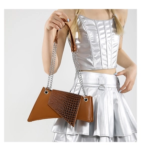 Detail of asymmetric brown PU leather handbag with crocodile pattern and silver chain