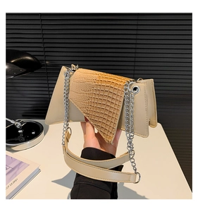 Detail of two-tone handbag with beige leather and brown croc-embossed trapezoid flap