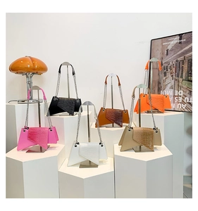 Detailed display of assorted crocodile embossed asymmetrical chain bags in various colors