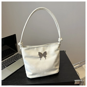 Détail du sac à bandoulière blanc avec boucle papillon argentée et sangle nouée