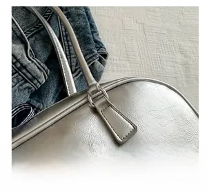 Close-up of metallic silver PU leather handbag with cracked texture and stitching