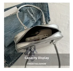 Capacity display of silver metallic PU handbag with a bow and daily essentials inside