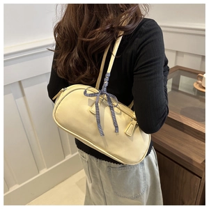 Close-up of cream PU leather shoulder bag featuring a blue checkered ribbon bow