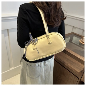 Detail of light beige PU leather shoulder bag featuring a stylish black and white plaid bow