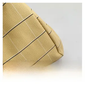 Close-up of yellow faux leather with black and white grid texture on a tote bag