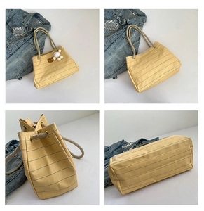 Detail of yellow checkered canvas tote bag with thick rope handles and soft plush charm