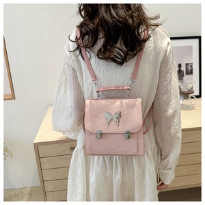 Pink mini butterfly backpack with silver hardware shown in a lifestyle home setting