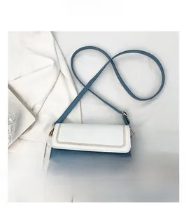 Detail of contrast stitch flap and navy quilted leather on stylish crossbody bag