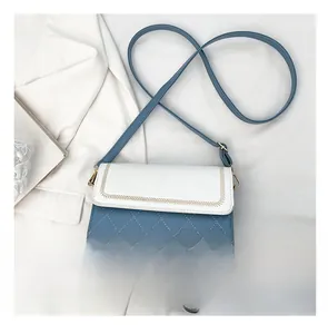 Size comparison of a blue and white crossbody bag with quilted texture and gold hardware