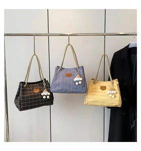 Three checkered canvas tote bags in black, blue, and yellow with woven rope handles