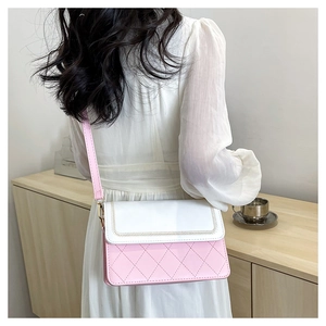 Detail of pink and white crossbody bag with quilted diamond pattern and braided trim
