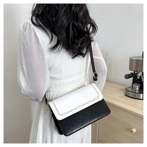 Detail of contrast stitch border and quilted rhombus texture on a mini crossbody bag