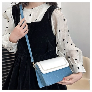 Detail of blue and white quilted crossbody bag with gold hardware and fine stitching