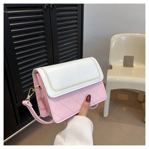 Detail of pink and white crossbody bag featuring quilted patterns and gold metal hardware