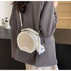 Details der runden Patchwork-Tasche mit Webstruktur, Pompon und Tragegriff