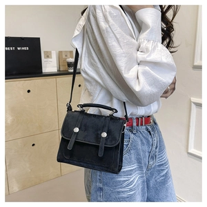 Detailed shot of retro black leather crossbody bag with silver buckles and handle strap