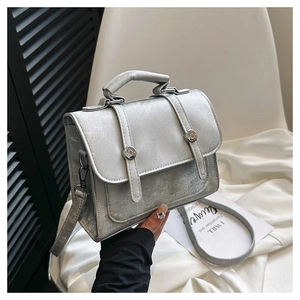 Close-up of silver textured PU leather handbag with metallic buckles and thin strap