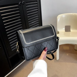 Minimalist black quilted crossbody bag with white stitching and golden hardware hand-held view