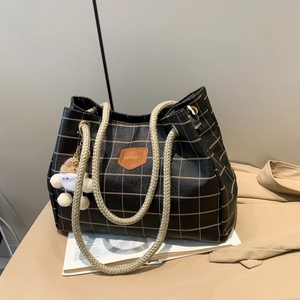 Black and beige plaid leather tote bag with thick woven handles and a cute bear charm