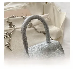 Détails du mini sac argenté à paillettes avec double nœud en strass et chaîne métal