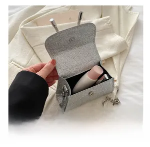 Détail montrant la capacité intérieure du mini sac de soirée argenté à paillettes