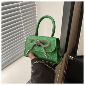 Détail du mini sac vert émeraude pailleté avec nœud en strass argenté et bandoulière