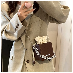 Detail of chocolate bucket bag with embossed richrabbit letters and drawstring liner