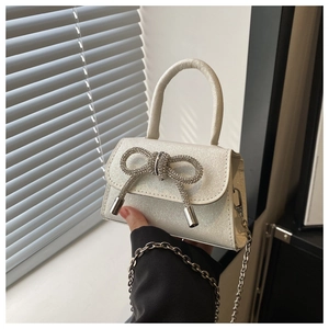 Gros plan détaillé du mini sac blanc perle avec texture pailletée et nœud strass