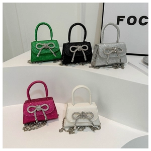 Détail de cinq mini sacs pailletés colorés avec nœuds en cristal et chaînes argent