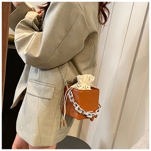 Modern brown square box crossbody bag with white drawstring pouch and silver chain strap