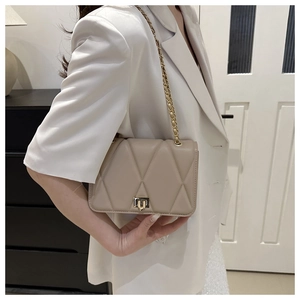 Detail der gesteppten kleinen Tasche in Apricot mit Goldkette und Drehverschluss
