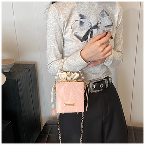 Détail du sac rose à motif marbre avec poignée perle et bandoulière dorée