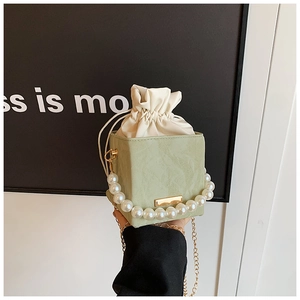 Détail du mini sac bandoulière vert clair avec poignée en perles et finitions dorées