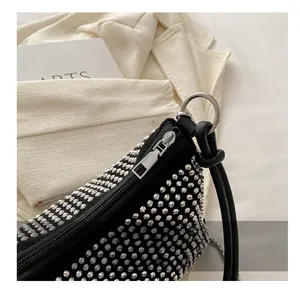 Close-up of sleek silver metal zipper and rivets on black minimalist underarm bag