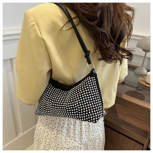 Detail of a chic black underarm bag with shimmering silver rhinestones and thin strap