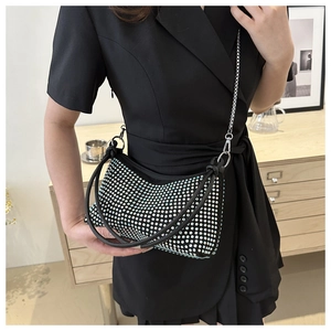 Detail of black rhinestone handbag showing shimmering crystals and elegant metal chain strap