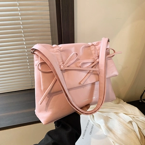 Chic pink bow shoulder bag with sleek faux leather finish and delicate strap