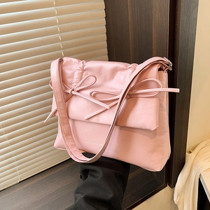Pink faux leather shoulder bag featuring ribbon bows and minimalist square design
