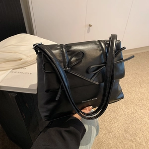 Chic black quilted pillow shoulder bag with bow accents and glossy PU leather finish