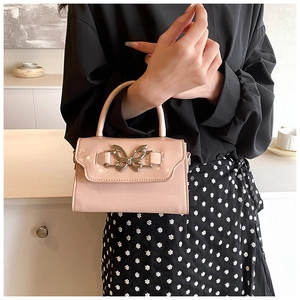 Close-up of pink glossy mini square bag featuring a decorative silver butterfly lock