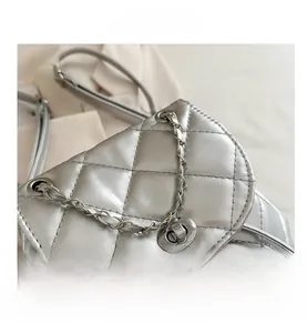 Detail of silver metallic quilted texture and metal turn-lock on a stylish mini backpack