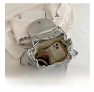 Interior view of silver quilted backpack showing capacity for phone and cosmetics