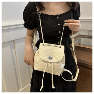 Detail of quilted mini backpack in cream faux leather with chain strap and twist lock