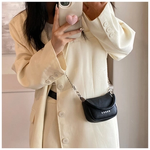Détail d'un mini sac bandoulière noir avec rivets étoiles argentés et chaînette