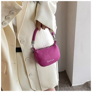 Vue détaillée du mini sac en cuir grainé magenta avec des rivets étoiles argentés